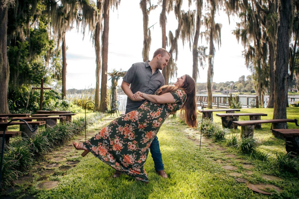 Engaged couple dipping in aisle at Knotted Roots on the Lake